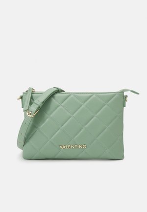 Bolso bandolera acolchado de Valentino en verde claro con correa ajustable y logo dorado en el frente sobre fondo blanco.