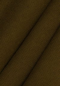 Gros plan d'un tissu tricoté côtelé vert olive foncé avec des plis diagonaux visibles et des lignes verticales texturées.