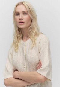 Korte mouwen, licht beige cardigan gemaakt van een gebreide stof met textuur, met een kabelpatroon en een sluiting met parelachtige knopen.