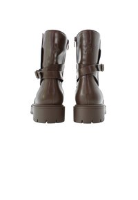 Botas de tobillo marrones con un acabado de cuero brillante, que cuentan con un cierre de cremallera lateral y correas entrelazadas. Suelas gruesas y estriadas para mayor tracción.