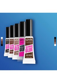 Fünf Tuben NYX Professional Makeup The Brow Glue in den Farbtönen Schwarz, Mittelbraun, Taupe, Klar und Dunkelbraun auf blauem Hintergrund.