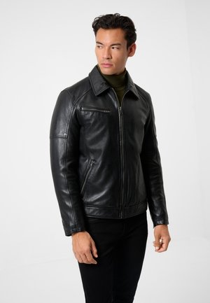 Sort læderjakke med lynlås foran, spidse krave og lynlåslommer. Glat tekstur, tætsiddende design og lange ærmer. Kombineres med mørke jeans.