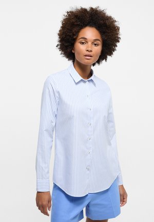 Camicia a righe blu chiaro e bianco con maniche lunghe e colletto appuntito, caratterizzata da una superficie liscia e piccoli bottoni.