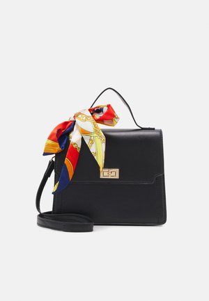 Sac à main en cuir noir avec poignée supérieure, fermoir doré, bandoulière amovible, et foulard coloré rouge, blanc, bleu et jaune à motif attaché à la poignée.