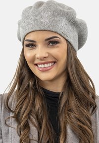 Beret de lana gris con un diseño texturizado, acentos plateados y adornos brillantes. Forma suave y redondeada con un ligero dobladillo.
