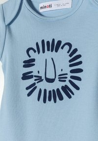 Light blue cotton onesie featuring a navy lion face print with whiskers, surrounded by a circular mane pattern and a tag at the neckline.