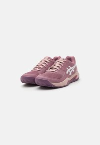 Purple athletic shoes with a textured mesh upper and light pink accents. Features laces and a rubber sole with patterned tread.