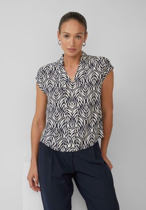 Blouse à manches courtes avec un motif de feuillage bleu marine et crème. Présente un décolleté en V et une coupe décontractée, fabriquée en tissu léger.