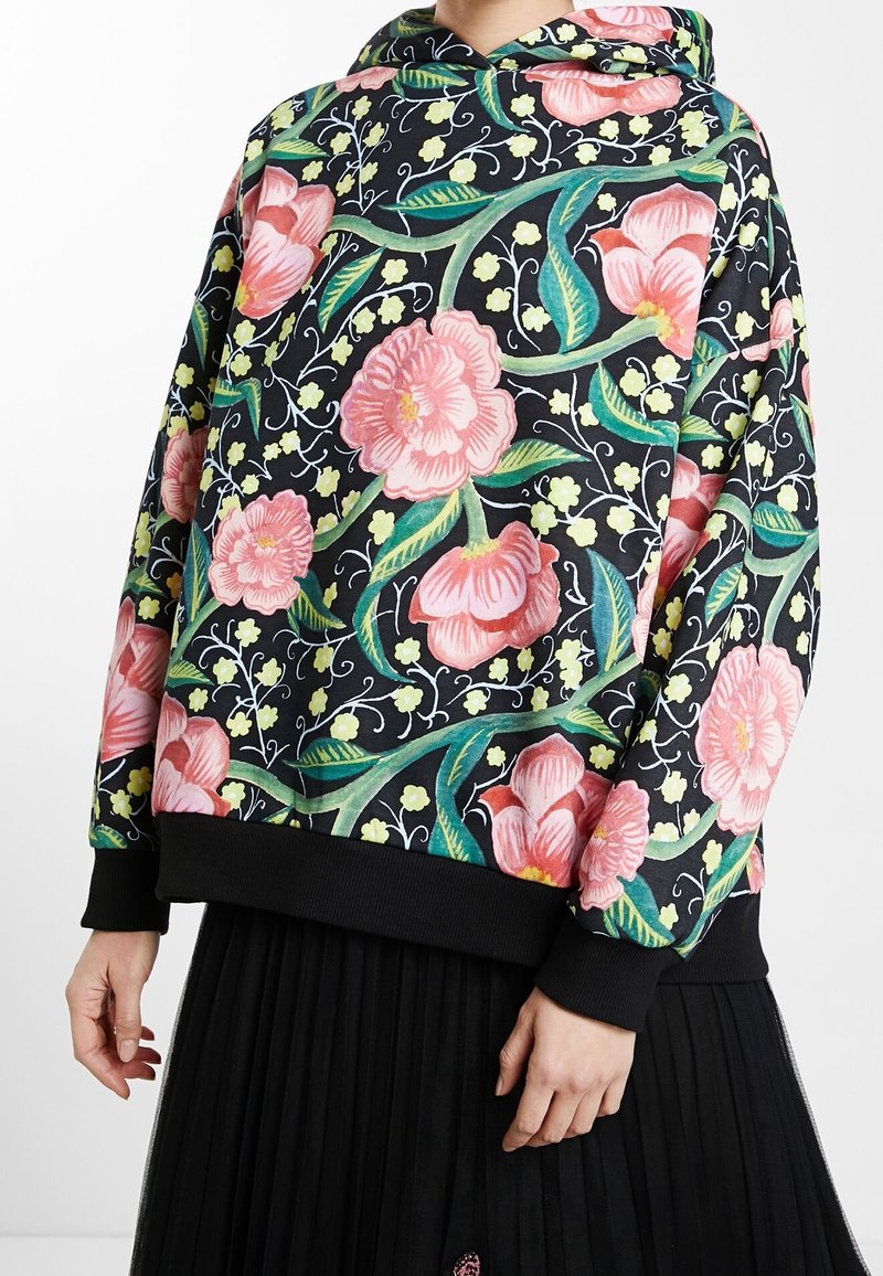 Kapuzensweatshirt mit schwarzem Hintergrund, versehen mit pinken Blumenmustern und grünen Akzenten. Gerippte Bündchen und Saum in Schwarz. Weiche Textur.