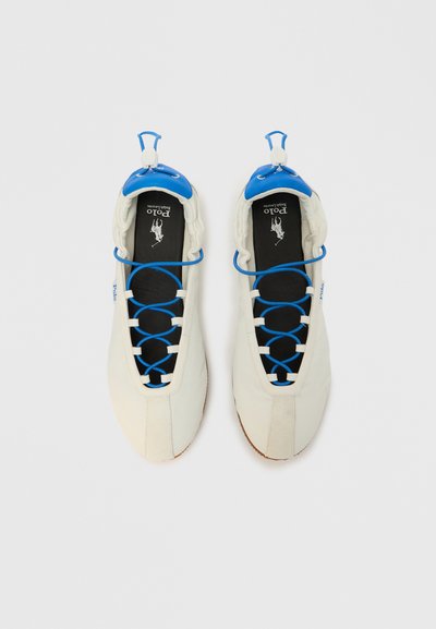 Λευκά αθλητικά παπούτσια με μπλε λεπτομέρεια, ελαστικό σύστημα κορδονιών, επενδεδυμένο κολάρο και μαύρους εσωτερικούς πάτους με λογότυπο. Ομαλή υφή, στρογγυλεμένο σχήμα.