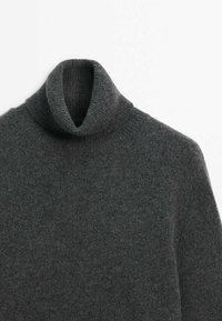 Pull à col roulé en maille côtelée gris foncé avec manches longues, présenté à plat sur un fond blanc.