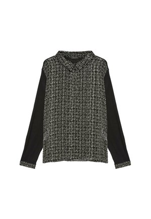 Camicia a maniche lunghe bianco e nero con una parte anteriore testurizzata e a fantasia e maniche nere piene. Presenta un colletto e maniche con polsini.