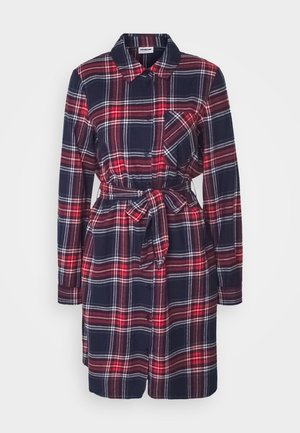 Sukienka z długim rękawem do kolan w czerwoną, granatową i białą kratę, z przodu zapinana na guziki, z kieszenią na piersi, kołnierzykiem i paskiem wiązanym w talii.