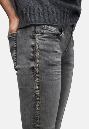 Szare dżinsy o slim fit, z teksturowanym akcentem w panterkę wzdłuż szwu bocznego oraz tradycyjnymi kieszeniami.