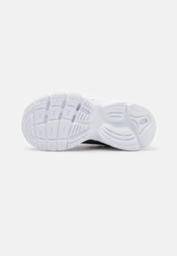 Suela de zapatilla deportiva negra con una superficie de goma blanca texturizada, que presenta patrones de banda de rodadura multidireccionales para mejorar la adherencia y la estabilidad.