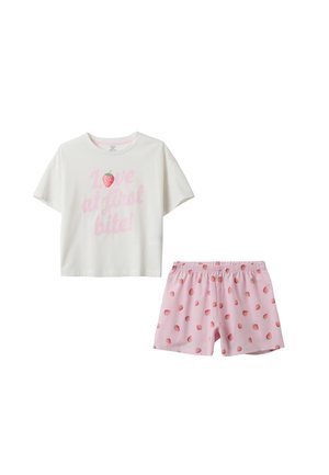 Camiseta blanca de manga corta con texto rosa "¡Amor a primera mordida!" y gráfico de fresa, combinada con pantalones cortos rosas cubiertos de pequeñas fresas.