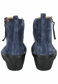 botines de ante en azul marino con un acabado texturizado, suela de goma negra, cremallera trasera y tirador para una fácil puesta.