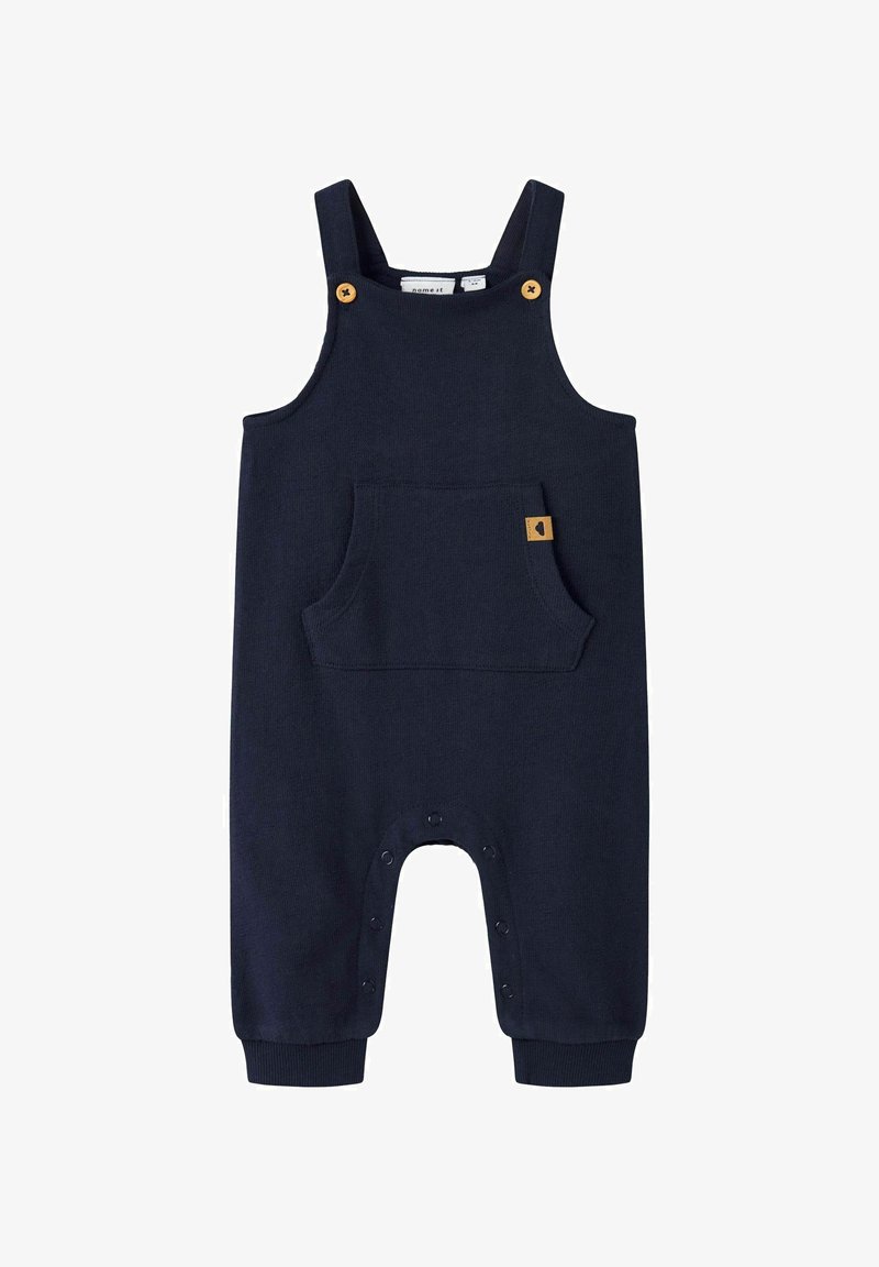 Tume sinine kombinesoon pehmest kangast, millel on reguleeritavad rihmad, eesmine tasku, helepruunid nupud ja alumised pressnupud.