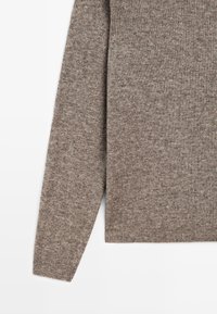 Maglione marrone lavorato a maglia con un motivo testurizzato, dotato di maniche lunghe e orlo dritto. Il materiale sembra morbido e flessibile.