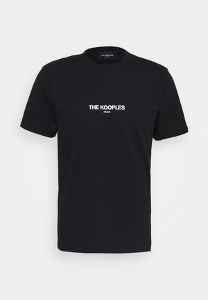 Musta puuvillapaita, jossa on pyöreä kaulus, lyhyet hihat ja valkoinen logo-teksti "THE KOOPLES PARIS" edessä.