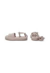 Beige Seilsandalen mit einer strukturierten Oberfläche, offenem Design und geknoteten Riemen. Verfügt über eine flache Sohle und einen schlichten, minimalistischen Stil.