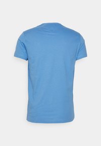 Prosta, niebieska koszulka z krótkim rękawem prezentowana z tyłu na białym tle, z okrągłym dekoltem i przeszyciem w pobliżu kołnierza.