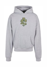 Pelēkā kapuce svičers, kas izgatavots no kokvilnas maisījuma, ar priekšējo kabatu. Iezīmēts ar zaļu trīclapu un uzrakstu "IRISH MOB" lentē zem tā.
