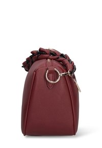 Borsa a mano rossa in ecopelle con design arrotondato, dettagli a catena sulla parte superiore, accessori in metallo dorato e chiusura con cerniera. Superficie testurizzata con cuciture visibili.