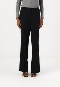 Pantalons noirs ajustés avec une coupe droite, en tissu lisse. Présente deux poches avant et une taille mi-haute.