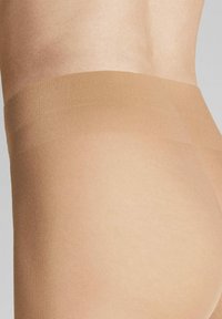 Beige opake Strumpfhosen mit glatter, dehnbarer Textur, ausgestattet mit einem hohen Bund für Komfort und einem schlanken Design.