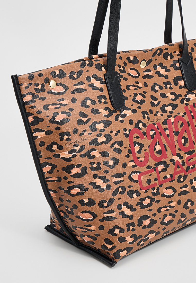 Torebka tote w brązowy wzór w cęgi z czarnymi akcentami i uchwytami, z wyraźnym czerwonym logo "Cavalli Class" oraz złotymi ćwiekami. Wykonana z materiału syntetycznego.
