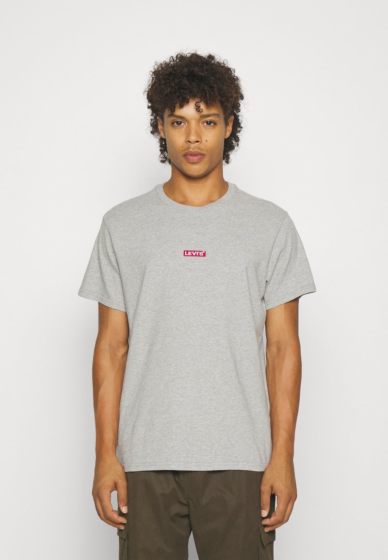 Tricou din bumbac gri cu mâneci scurte, având un logo roșu Levi's centrat pe piept. Guler rotund simplu și croială lejeră.