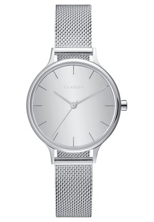 Hopeinen Skagen-käsikello, jossa minimalistinen pyöreä kellotaulu, verkkomainen ruostumattomasta teräksestä valmistettu ranneke, ohuet tunti- ja minuuttiviisarit sekä hillityt tuntimarkkerit.