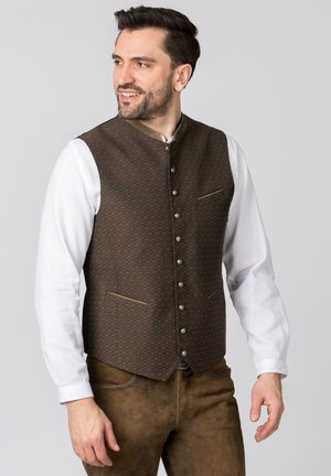 Braun gemusterte Weste mit Stehkragen, ausgestattet mit silbernen Knöpfen und zwei Vorderaschen, getragen über einem weißen Langarmhemd.