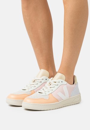 Sneakers basse in rosa, bianco e arancione, caratterizzati da un design perforato, dettagli testurizzati e una suola in gomma. Include anche un logo.