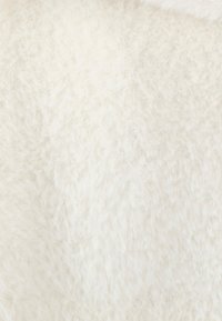 Tejido blanco esponjoso con una textura suave, presentando una superficie ligeramente desigual y variaciones sutiles en el tono. Ideal para prendas o accesorios acogedores.