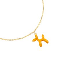Collier en chaîne dorée featuring un pendentif en forme de chien ballon jaune joufflu, avec une texture lisse et des bords arrondis, mettant en avant un design fantaisiste.