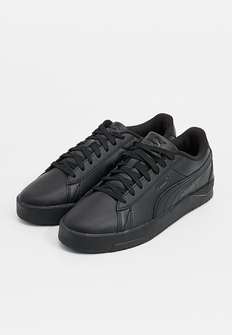 Schwarzes Paar Leder-Sneaker im Low-Top-Stil mit schwarzen Schnürsenkeln und Puma-Logo an den Seiten und auf der Zunge, dargestellt vor einem weißen Hintergrund.