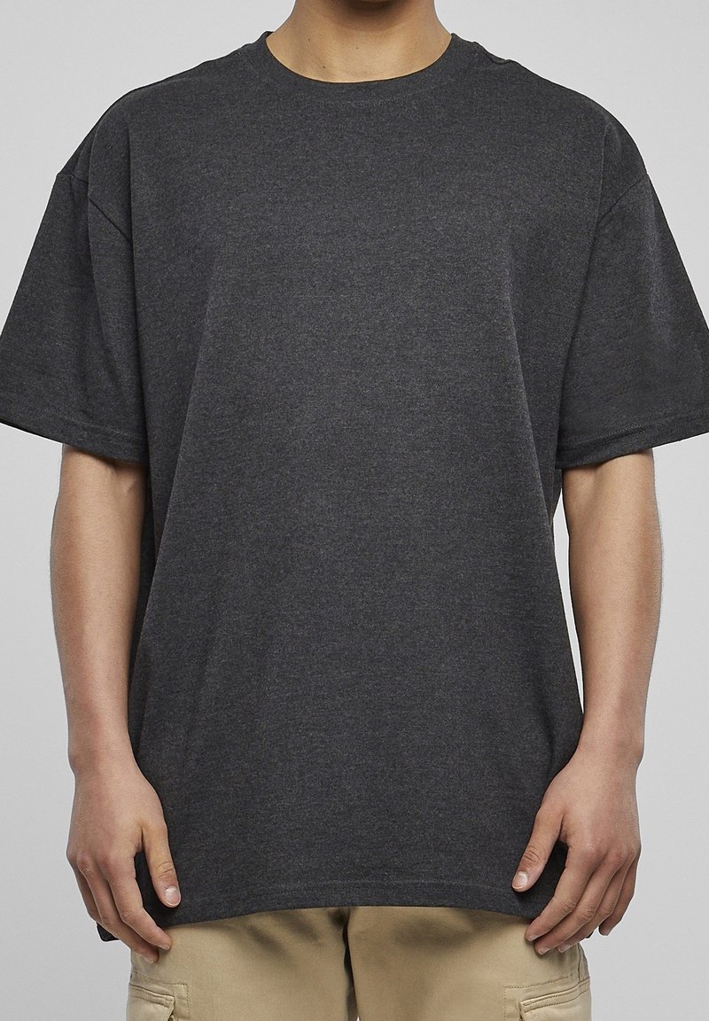 Tmavě šedé oversized tričko vyrobené z měkké bavlny. Má kulatý výstřih a krátké rukávy s volným střihem.