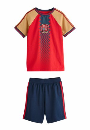 Rød og tan kortærmet sportstrøje med blå zigzag og Spaniens våbenskjold kombineret med marineblå shorts med røde sidelommer.