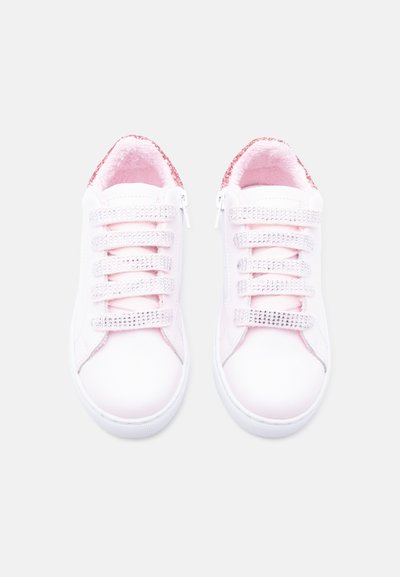 Baskets blanches pour enfants avec doublure intérieure rose, brides pailletées et fermetures éclair latérales, conçues pour un enfilage facile et un éclat décoratif.