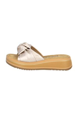 Beige slide sandal with a knotted strap design, featuring a cushioned insole, textured upper, and a thick, light-colored sole.