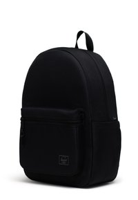 Schwarzer Stoff-Rucksack mit runder Form, vorderer Reißverschlusstasche, Logo-Patch und einem oberen Griff für einfaches Tragen. Glatte Textur.