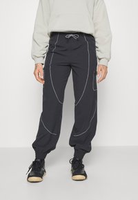 Navy joggings met een trekkoord in de taille, elastische manchetten, zijzakken met rits en contrasterende stiksels voor extra detail.