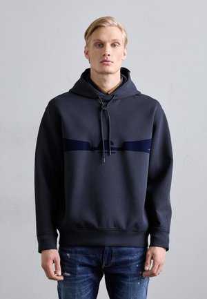Navy hoodie featuring a drawstring, large kangaroo pocket, and contrasting horizontal stripe across the chest. Soft material, relaxed fit.
