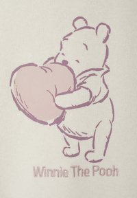 Winnie Puuh, der mit beiden Armen ein großes Herz hält, umrahmt von sanftem Lila auf einem hellbeigen Stoffhintergrund.