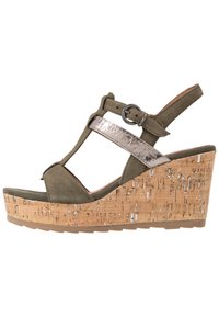 Sandale compensée vert olive avec une plateforme en liège, dotée d'une lanière argentée métallique et d'un bout arrondi. Boucle réglable sur la cheville.