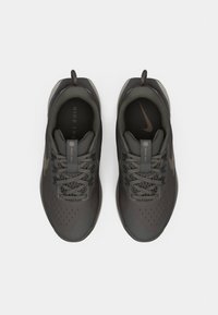 Nike treeningjalatsid tumedashallis, millel on tekstuurne pealis, tugevdatud varvas, silmapaistev lapp ja mugavuse tagamiseks polsterdatud krae.