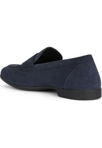 Scarpa slip-on in suede blu navy con punta arrotondata e design minimal. Presenta una texture liscia e una suola in gomma nera.