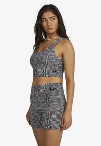 Black and white striped crop top and shorts set, featuring a soft texture and fitted design. Notable logo patch on the shorts.